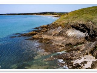 Vue de la petite crique discrète au pied de la falaise, accessible depuis les airs, cachée entre mer et falaise
