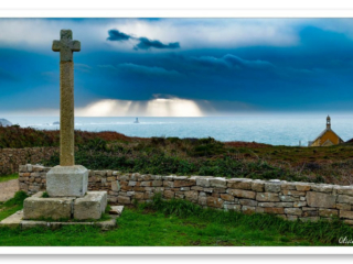 depuis la Pointe du Van, entre la chapelle et la croix en granit, le ciel s&#039;ouvre sur le phare de la Vieille