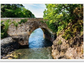 Petit pont de pierre à Audierne, laissant passer l&#039;eau de la rivière vers l&#039;océan
